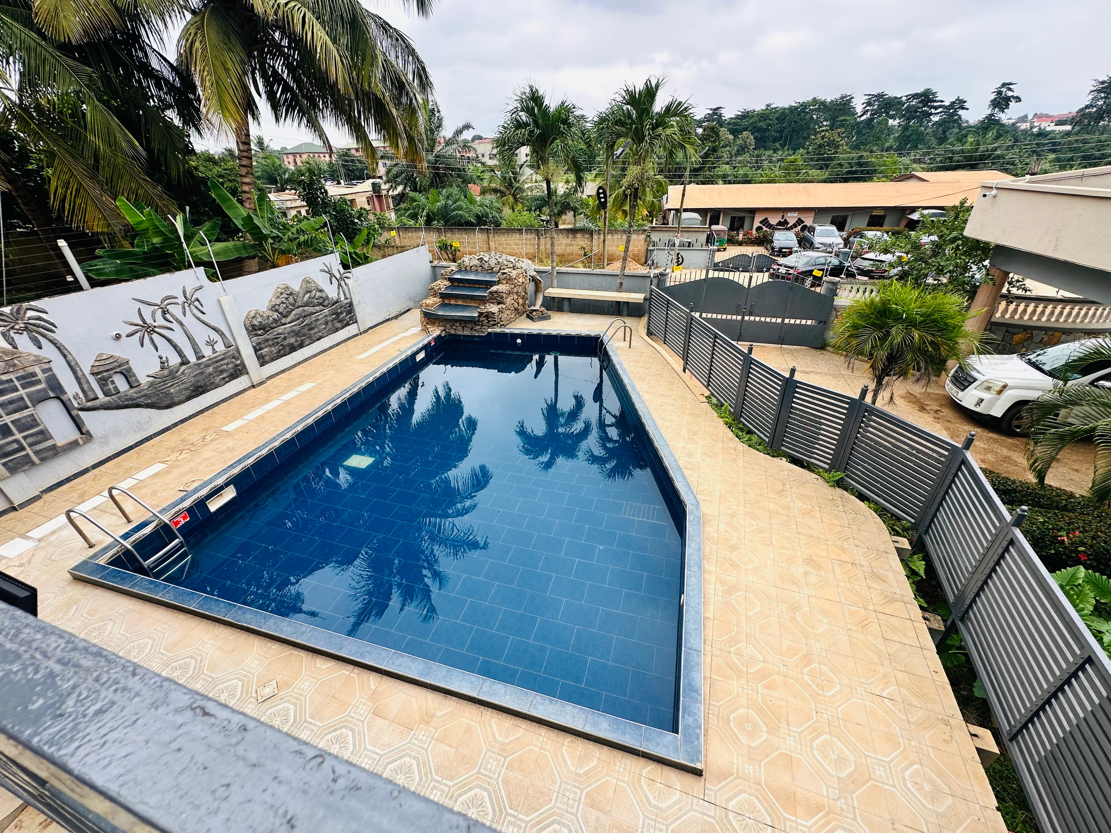 Pool with carved African relief mural and stone waterfall