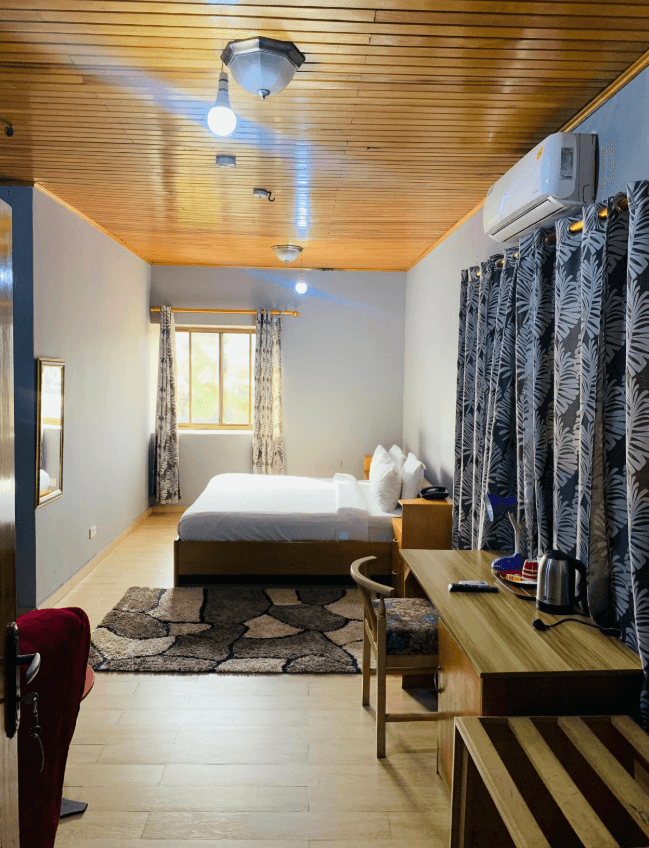 Mini-Suite with wood-panelled ceiling, work desk and patterned curtains
